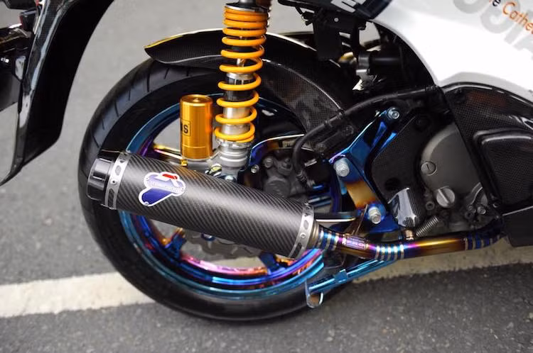 Ở phía sau, chiếc xe cũng có hàng loạt các "đồ chơi" hàng khủng, có thể kể tới bao gồm cặp phuộc Ohlins từ SH300i, phanh đĩa với heo Brembo cùng đĩa Galfer và cây pô Termignoni lon dài bằng sợi carbon được lấy từ xe Ducati, đi kèm cổ pô titan 7 màu đẹp mắt.