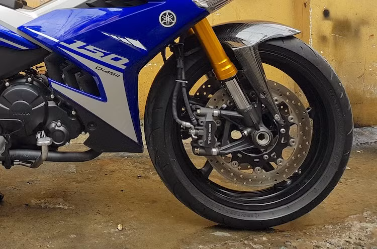 Thay vì phuộc nguyên bản, chiếc xe đã được ViettuanGC độ cặp phuộc USD cắt ngắn từ mẫu superbike Kawasaki ZX-14R. Bên cạnh mâm trước R6 kèm lốp 120/70/17, hệ thống phanh của chiếc Exciter 150 độ khủng cũng được nâng cấp lên đĩa kép với cặp heo Tokico 4 piston. Dè trước bằng sợi carbon kết thúc những thay đổi ở "dàn chân" trước trên xe.