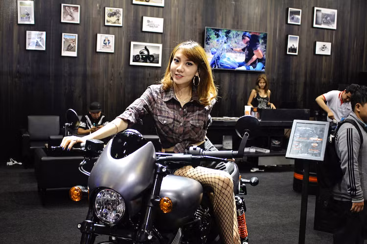 Tương tự như Ducati đã làm với dòng Scrambler, khu trưng bày của hãng xe Mỹ hơn trăm tuổi Harley-Davidson cũng hội tụ những người đẹp đầy vẻ cá tính, "phong trần" giống những mẫu xe của thương hiệu này.