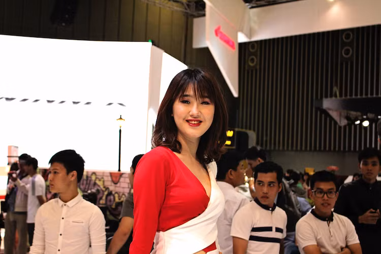 "Ông lớn" Honda góp mặt với dàn người đẹp trong 2 "bộ cánh khác nhau. Trong đó, phần lớn thời gian khách thăm quan sẽ được nhìn thấy những người đẹp thân tiện trong bộ đồng phục với tông màu đỏ trắng quen thuộc. Ở các show diễn, mỗi người mẫu từ Honda sẽ có trang phục khác nhau, tùy vào dòng xe được họ "làm nền".