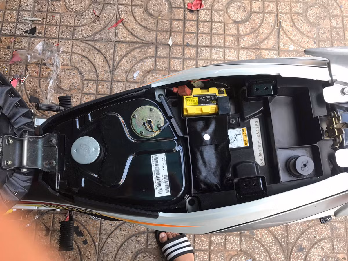 Bình xăng và khoang chứa đồ dưới yên xe còn bóng bẩy, hoàn toàn không trầy xước hay có bất kỳ dấu vết nào. Là một mẫu xe 2 kỳ nên Satria 120 có thêm bình dầu rời nằm ở gần lẫy khóa yên. Các hộc chứa đồ dưới yên xe chỉ vừa đủ chỗ chứa một số dụng cụ sửa chữa đơn giản.