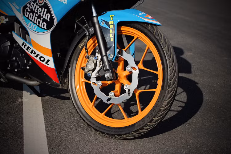 "Dàn chân" của chiếc xe đã được độ lại toàn bộ. Thay vì mâm 5 cánh kép nguyên bản, chiếc xe đã được chủ nhân thay cặp mâm 6 cánh đặc trưng của "kỳ phùng địch thủ" Honda Winner 150. Bộ phuộc của Winner cũng được chế vào xe, loại bỏ nhược điểm của phuộc Exciter. Hệ thống phanh trước cũng được nâng cấp với heo Brembo 2 pis đối xứng và đĩa Galfer.