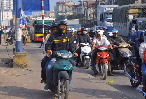 Ùn tắc kéo dài, nhiều người điều khiển xe máy lên vỉa hè ven đường sắt vượt trước. 