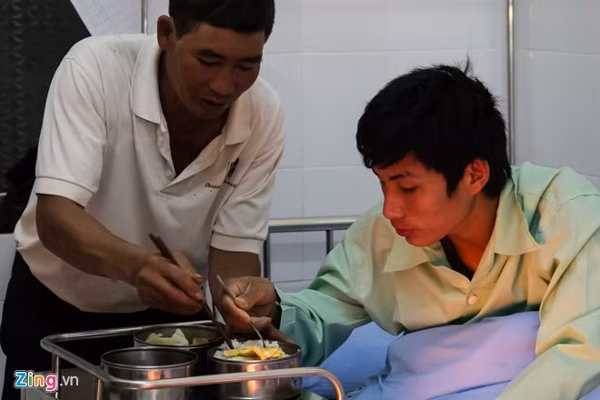 Được sự giúp đỡ của người bác, anh ngồi dậy để ăn cơm chút cơm.