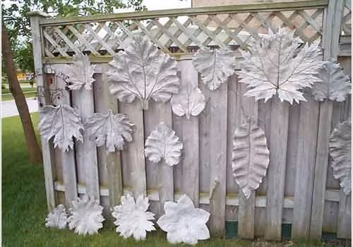 Dùng những chiếc lá, bông hoa đúc bằng bê tông gắn lên hàng rào nhà mình cũng là một cách trang trí sân vườn đẹp. Bạn có thể sơn màu cho những chiếc lá để chúng trông ấn tượng hơn.