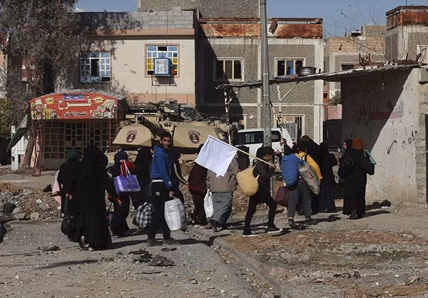 Thanh niên cầm theo cờ trắng trong đoàn người chạy khỏi Mosul. Ảnh FNA