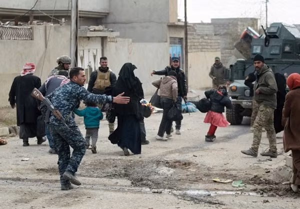 Một binh sỹ Iraq hướng dẫn người dân lên xe. Ảnh FNA