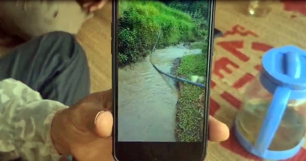 Người dân cho phóng viên xem đoạn video ghi lại hình ảnh dòng nước suối xuất hiện màu lạ.