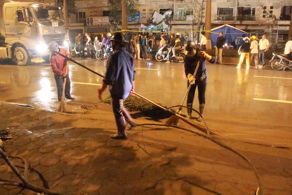 Lao công quét dọn sau khi phun nước rửa đường.