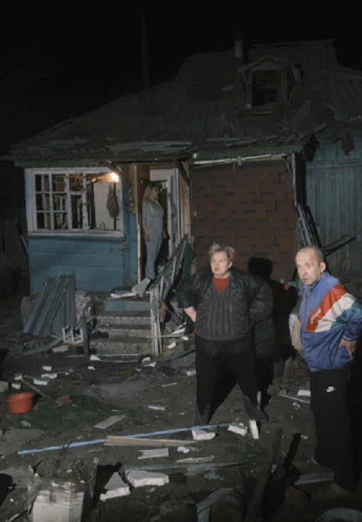 Người dân ở Kharkov đứng nhìn ngôi nhà của họ bị hư hại sau cuộc oanh kích của Nga.