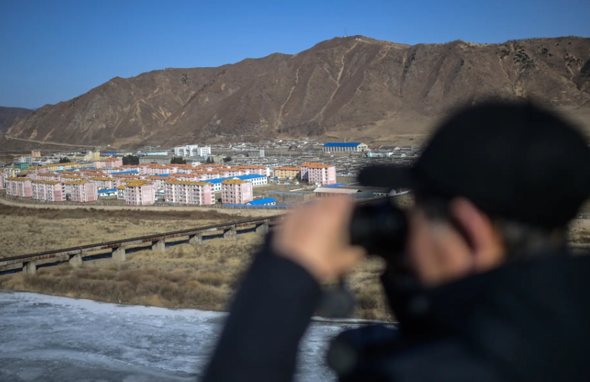 Một người đàn ông dùng ống nhòm quan sát thành phố Namyang.