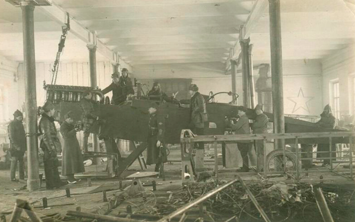 Các công nhân sửa chữa một chiếc máy bay trong xưởng hàng không.