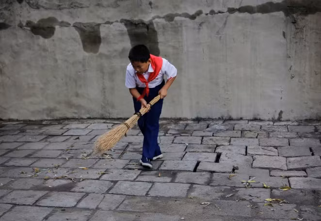 Một nam sinh quét dọn vỉa hè ở thủ đô Bình Nhưỡng vào ngày 28 tháng 7 năm 2017.