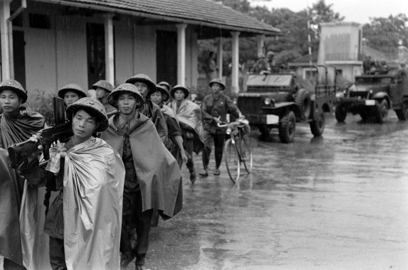 Lực lượng Việt Minh tiến vào Thủ đô Hà Nội dưới cơn mưa đầu mùa. Nguồn ảnh: TL.