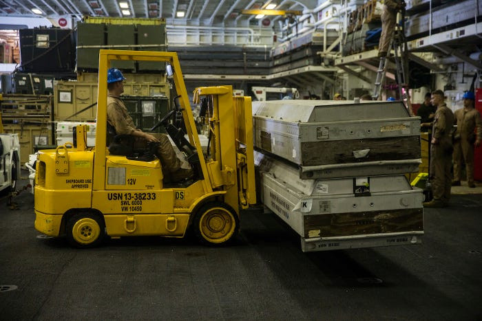 Đủ các loại phương tiện như xe nâng, xe cẩu được huy động để bốc hàng hoá, hậu cần từ kho chứa chất lên các phương tiện vận tải đổ bộ. Nguồn ảnh: BI.