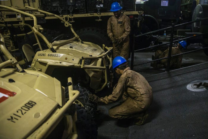 Các loại phương tiện vận tải cỡ lớn như xe địa hình, xe tải cũng được tháo bánh, xếp gọn gàng bên trong không gian chật chội của tàu đổ bộ. Nguồn ảnh: BI.