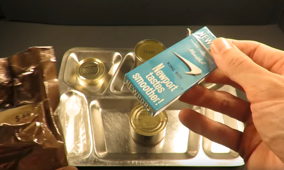 Mở gói đồ phụ trợ, bên trong có bao gồm một bao thuốc lá bốn điếu cỡ lớn. Từ sau năm 1972, các khẩu phần ăn dã chiến của lính Mỹ không còn bao gồm thuốc lá. Nguồn ảnh: MREinfo.