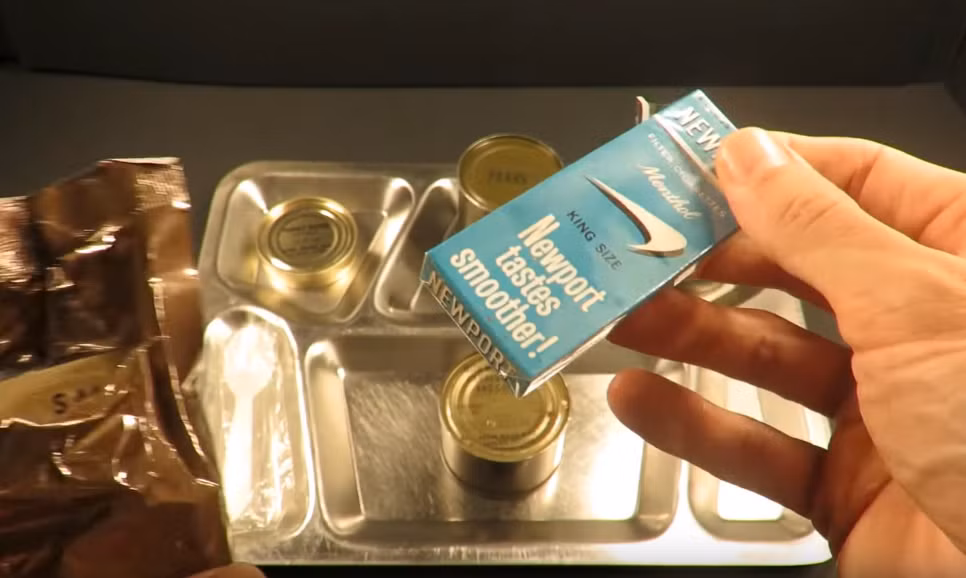 Mở gói đồ phụ trợ, bên trong có bao gồm một bao thuốc lá bốn điếu cỡ lớn. Từ sau năm 1972, các khẩu phần ăn dã chiến của lính Mỹ không còn bao gồm thuốc lá. Nguồn ảnh: MREinfo.