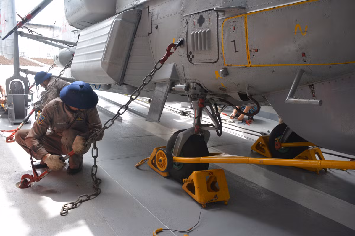 Trực thăng được cố định xuống sàn tàu bằng xích và chốt, đảm bảo chiếc Ka-28 không bị trượt khỏi vị trí khi tàu di chuyển vào khu vực biển động. Nguồn ảnh: QĐND.