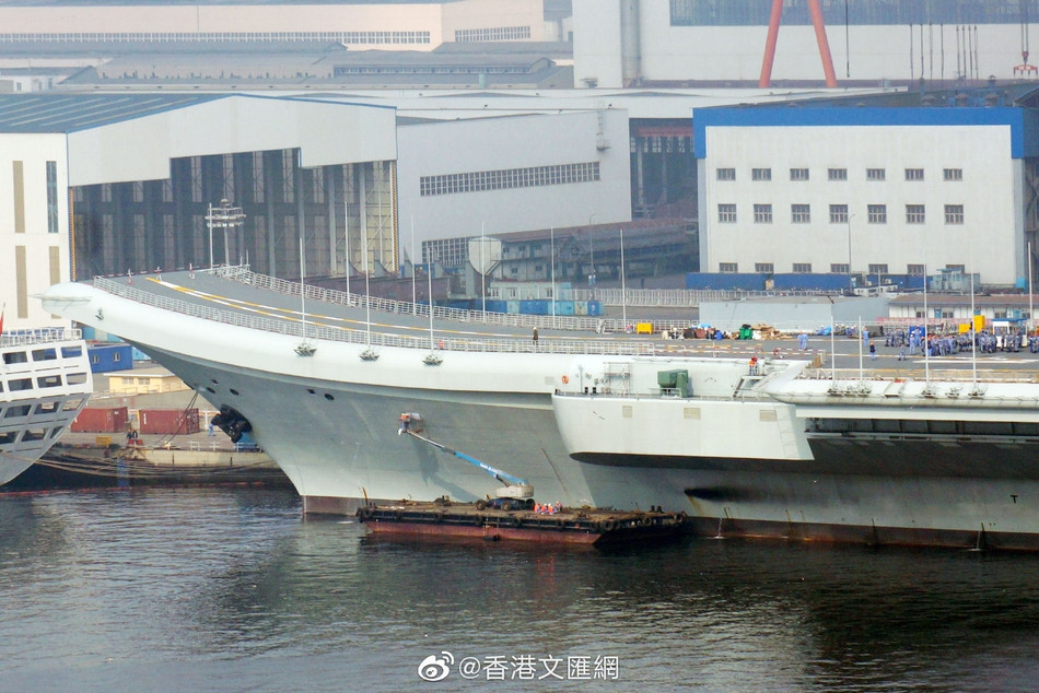 Xà lan với cần cẩu cỡ nhỏ tiếp cận thân tàu, bắt đầu viết số hiệu của Tàu sân bay Type 001A lên thân của nó. Nguồn ảnh: Sina.