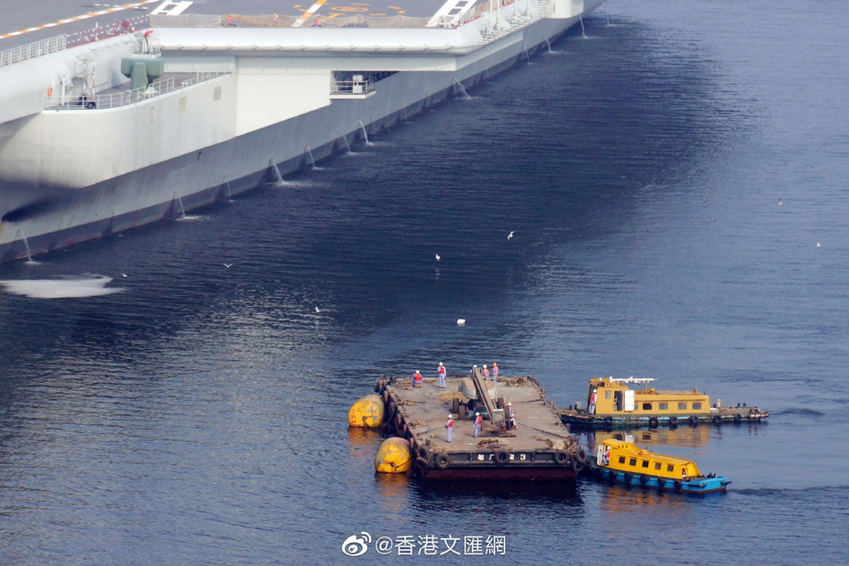 Trong những hình ảnh mới nhất được ghi lại tại Nhà máy Đóng tàu Đại Liên - nơi hàng không mẫu hạm Type 001A được neo đậu, một xe cẩu cỡ nhỏ cùng với một xà lan có chở theo xe cẩu đã được đưa vào tiếp cận tàu sân bay này. Nguồn ảnh: Sina.