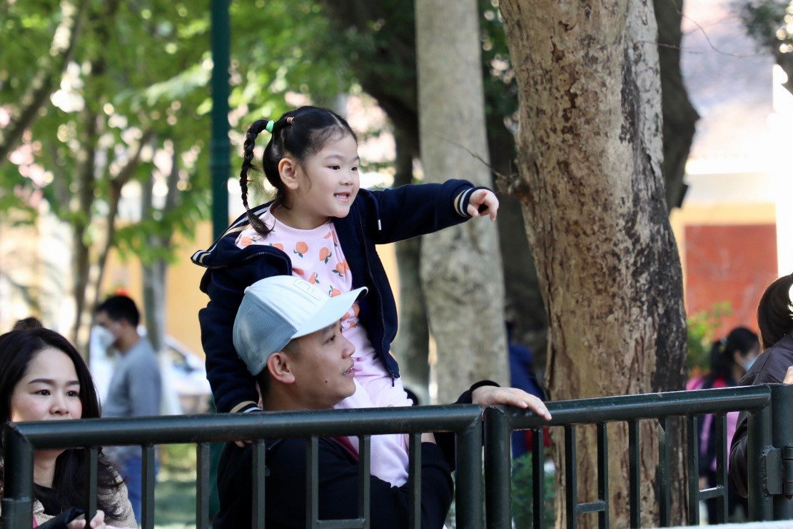 Các em nhỏ được bố mẹ bế, cõng để ngắm muôn loài thú trong công viên Thủ Lệ.