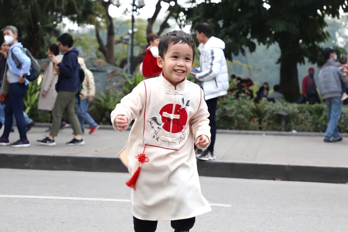 Nhiều em nhỏ được bố mẹ diện bộ đồ Tết để xuống phố du xuân.