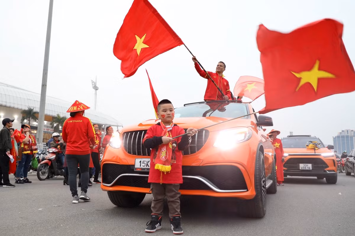 Một cổ động viên nhí dương lá cờ Tổ quốc cổ vũ trước sân vận động Mỹ Đình.