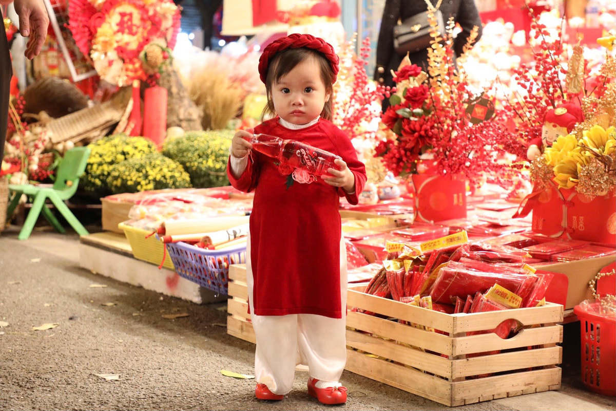 Các em nhỏ cũng được bố mẹ diện bộ đồ Tết rực rỡ lên Hàng Mã dạo phố.