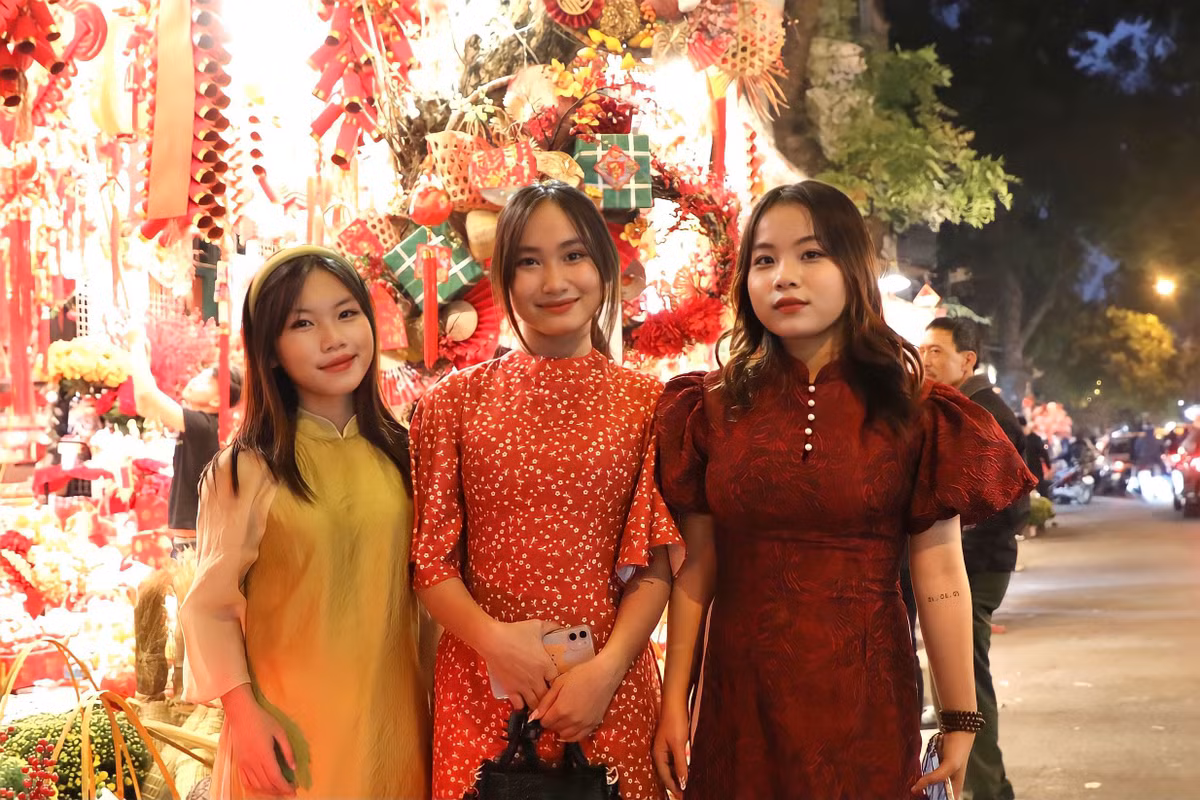 Nhóm 3 bạn học sinh lớp 12 ở Bắc Ninh ra Hà Nội vui chơi, chụp ảnh kỷ niệm. Bạn Nguyễn Thị Bình (đầu tiên bên phải) cho biết: "Hàng Mã là địa điểm chúng em yêu thích nhất. Mỗi dịp lễ, Tết chúng em hay tới đây để chụp ảnh. Năm nay mỗi người đã diện bộ đồ Tết thật đẹp, hi vọng là sẽ chụp được nhiều ảnh đẹp."
