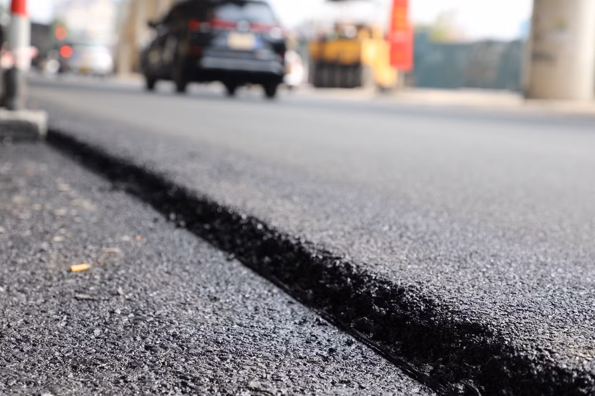 Mặt đường được trải lớp nhựa còn nguyên mùi mới.