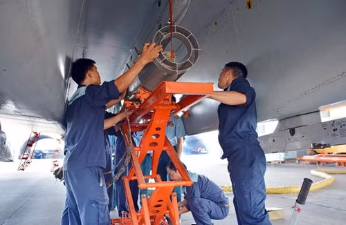 Nhân viên kỹ thuật lắp bom và rốc két vào máy bay. Ảnh: QĐND.