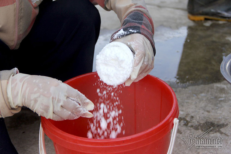 Cán bộ xã pha thuốc để phun khử trùng.