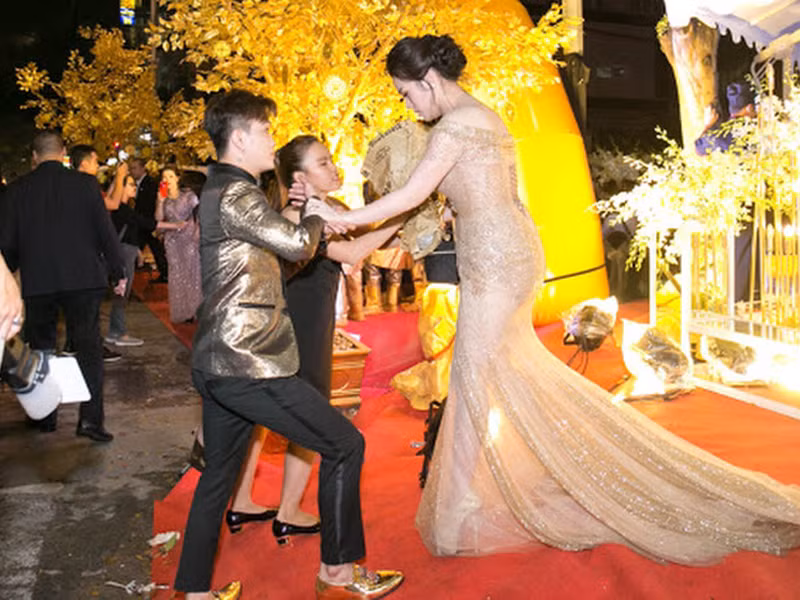 Hình ảnh TiTi dìu Nhật Kim Anh khi cô di chuyển gặp khó khăn do trang phục. Ảnh: Yan