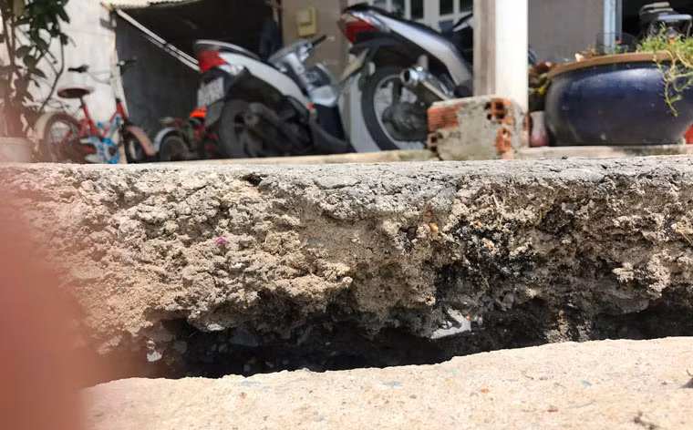 Vết nứt mặt đường nhựa bêtông khá sâu và rộng, kéo dài ra tận con sông Rạch Tôm.