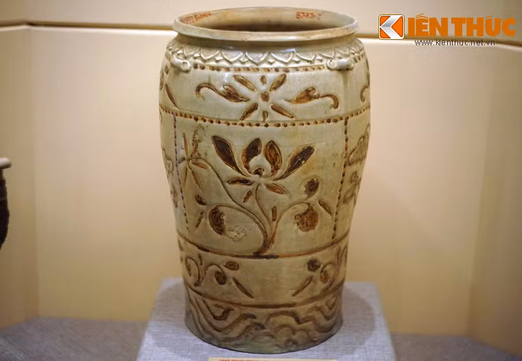 Thạp gốm hoa nâu trang trí hình hoa sen, sóng nước. Đồ gốm hoa nâu thời Trần thường thấy mô tả hoa lá sen theo xu hướng hiện thực: sen dây, sen cành và cả khóm hoa lá sen như trên thạp, chậu, chum, liễn...