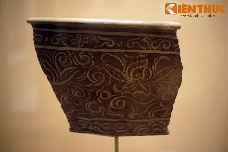 Mảnh chậu gốm hoa nâu trang trí hoa cúc dây. Hoa cúc, tuy không phổ biến như hoa sen nhưng cũng thấy thể hiện theo kiểu chạm khắc nổi, khắc và tô nâu rồi cả vẽ nâu dưới men trắng ngà.