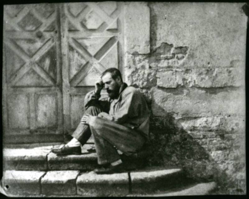 Quý ông suy tư bên cổng nhà.