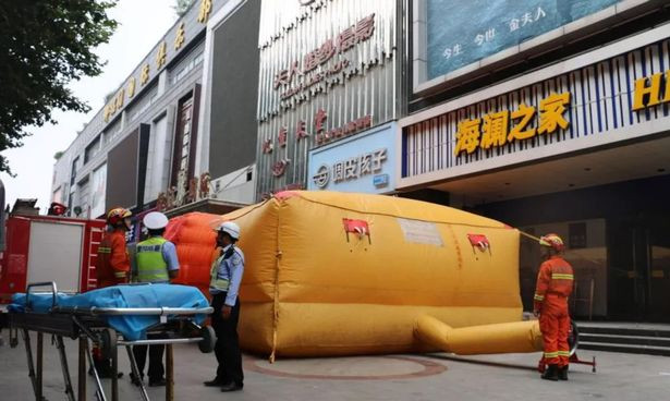 Hàng loạt dụng cụ hỗ trợ cứu hộ đã sẵn sàng bày ở dưới tòa nhà nơi cô gái đứng.