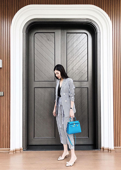 Á hậu Tú Anh tạo dáng chụp ảnh trước cửa nhà.