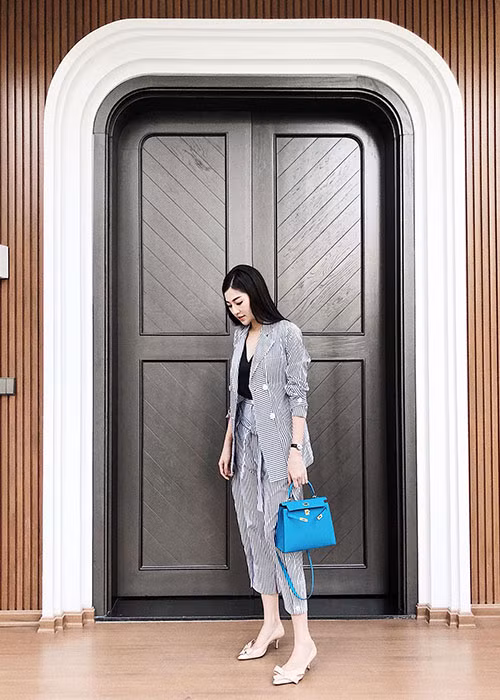 Á hậu Tú Anh tạo dáng chụp ảnh trước cửa nhà.