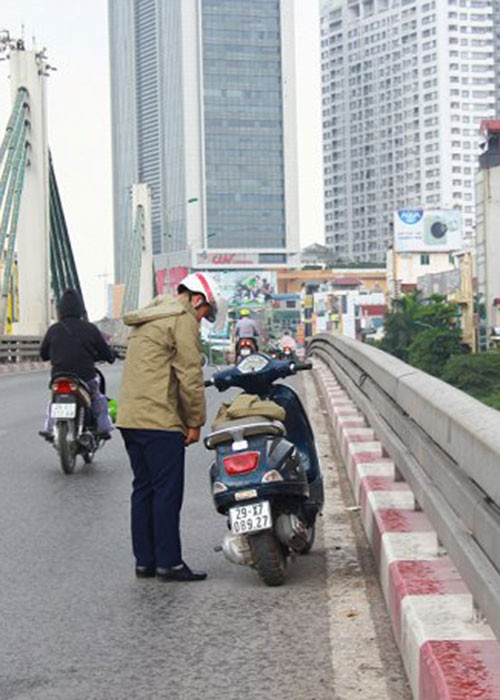 Người dân dừng xe trên cầu vượt Ngã Tư Sở để mặc áo mưa.