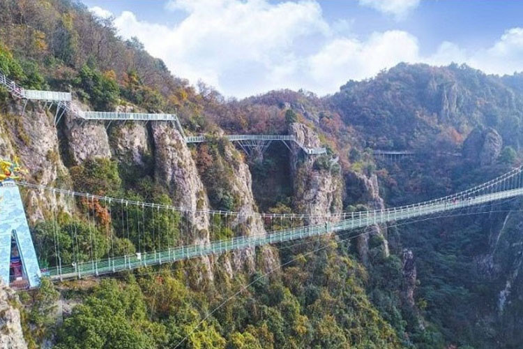 Cầu treo bằng kính ở Hà Bắc: Cầu dài 488 m, nằm ở độ cao 218 m, nối hai ngọn núi trong khu thắng cảnh Hồng Nhai Cốc. Là cầu treo, nên sự lắc lư qua lại của nó mới thực sự là nỗi kinh hãi của nhiều người. Các nhân viên được bố trí dọc theo cầu để kịp giúp đỡ những ai "yếu tim" qua đây. Ảnh: Siasat.com.