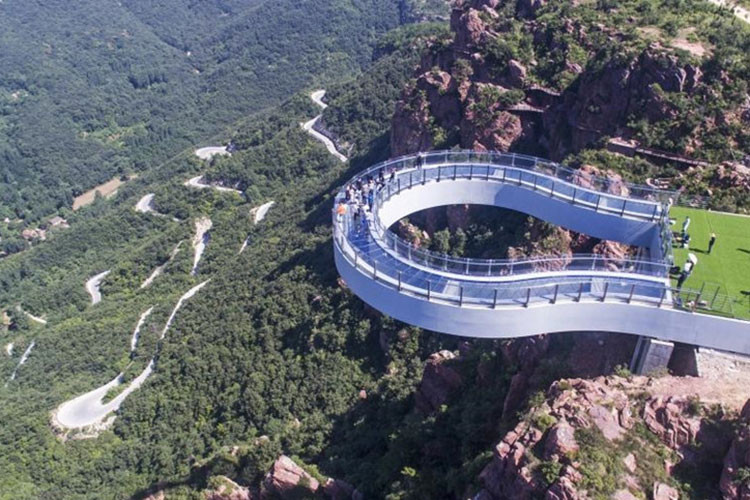 Fuxi Mountain Skywalk: Nằm ở núi Phục Hy (Hà Nam), "lối đi trên không" hình móng ngựa bằng thép và kính này nặng đến 3.000 tấn, vừa mở cửa cách đây không lâu. Từ vách núi nhô ra đến 30 m, Fuxi Mountain Skywalk đã phá vỡ kỷ lục của công trình tương tự là Arizona's Grand Canyon Skywalk (Mỹ). Chỉ những du khách đủ dũng cảm mới dám nhìn vực sâu 360 m bên dưới qua lớp kính trong suốt. Ảnh: Ecns.cn.