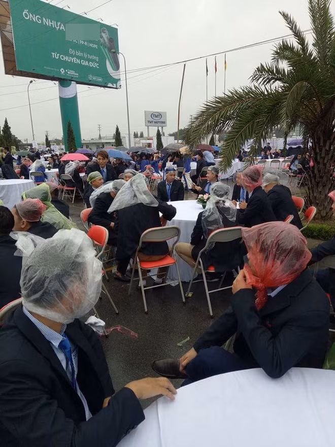 Các khách mời trùm áo mưa, đội nilon, cầm ô che... khi tham dự một tiệc cưới ngoài trời ở Hưng Yên năm 2017.