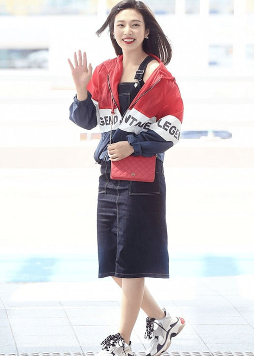 Joy (Red Velvet): Joy có sự kết hợp khá mới mẻ và lạ mắt khi mặc váy yếm mà không có áo thun kết hợp bên trong. Thành viên Red Velvet chỉ mặc áo khoác thể thao bên ngoài và hoàn thiện phong cách với đôi giày thể thao dáng thô kệch đang được ưa chuộng thời gian gần đây.