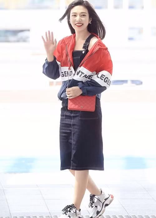 Joy (Red Velvet): Joy có sự kết hợp khá mới mẻ và lạ mắt khi mặc váy yếm mà không có áo thun kết hợp bên trong. Thành viên Red Velvet chỉ mặc áo khoác thể thao bên ngoài và hoàn thiện phong cách với đôi giày thể thao dáng thô kệch đang được ưa chuộng thời gian gần đây.