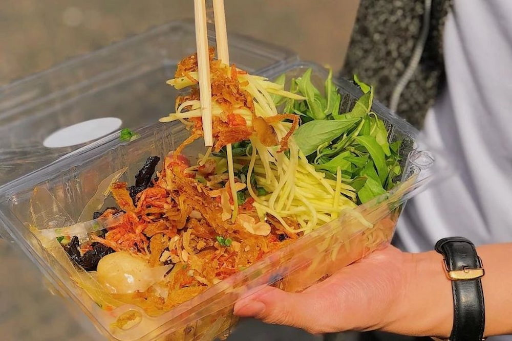 Bánh tráng trộn với xoài, khô bò, rau răm và nước sốt chua cay khiến ai ăn một lần cũng ghiền. Ảnh amthucviet