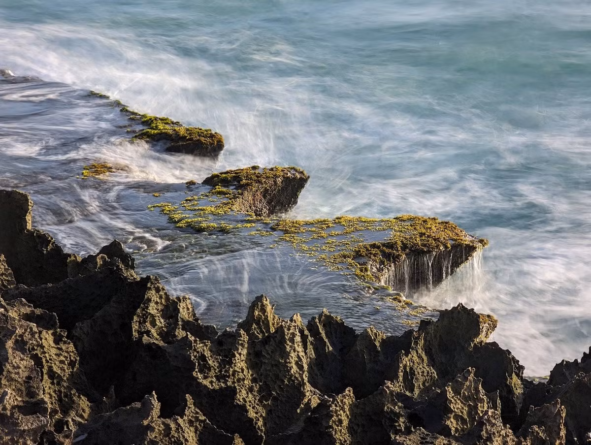 Điều đặc biệt nhất ở Hang Rái chính là hiện tượng "thác nước trên biển" độc đáo. Khi sóng biển xô vào bờ, nước tràn lên bề mặt đá rồi từ từ đổ xuống qua các khe đá, tạo nên những dòng thác nhỏ trắng xóa. Ảnh Dulichvietnam