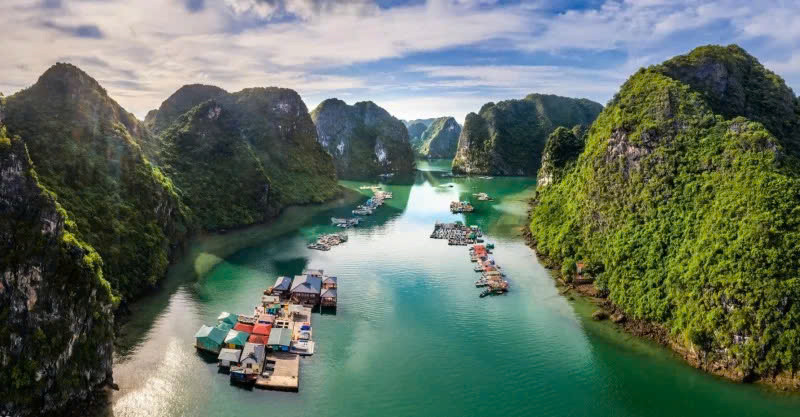 Làng nằm lọt thỏm giữa những dãy núi đá vôi sừng sững, bao quanh là làn nước xanh ngắt, yên ả quanh năm. Chính khung cảnh ấy đã biến Cửa Vạn thành một bức tranh thủy mặc sống động, nơi thời gian như ngừng lại giữa nhịp sống hiện đại. Ảnh Internet